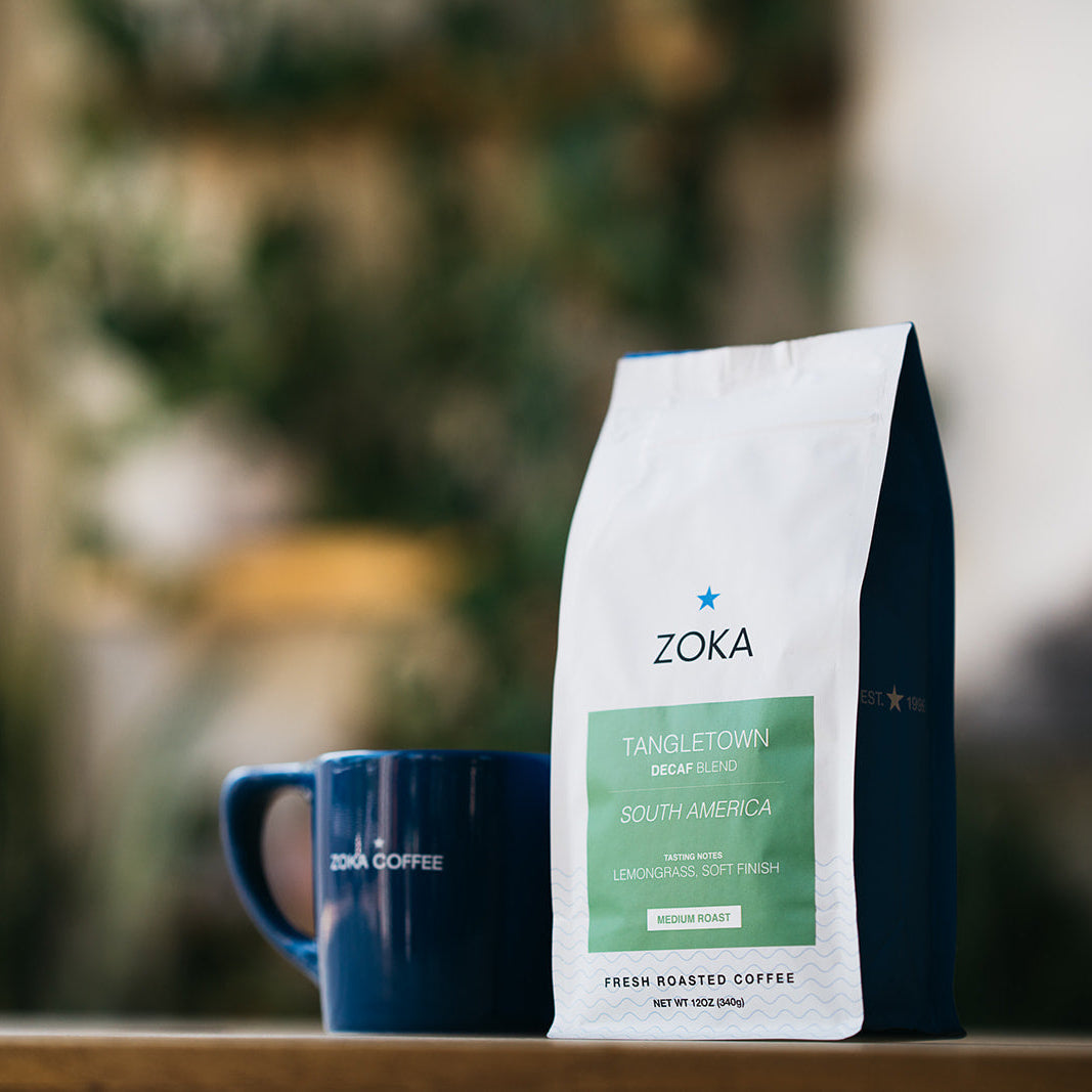 Decaf Tangletown bag next to coffee cup
